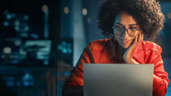 Image of a smiling woman looking at her laptop