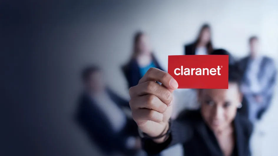 Business people with one holding a card with Claranet on