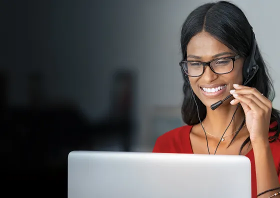 Female on laptop speaking to a customer on a headset