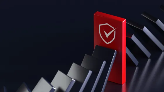 Falling black dominos with a dominant red domino standing tall with a Claranet Cybersecurity logo on it